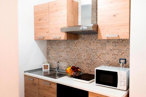 a kitchen with a sink and a microwave at INFORMIS B&B in Capua