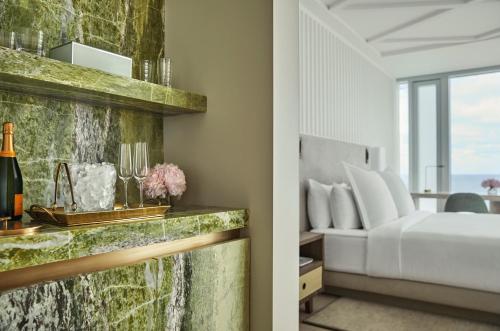 a hotel room with a bed and a bedroom with a window at Four Seasons Hotel at The Surf Club in Miami Beach