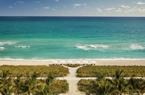 an aerial view of a beach with umbrellas and the ocean at Four Seasons Hotel at The Surf Club in Miami Beach