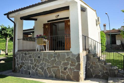 a small house with a balcony with a stone wall at Hotel Il Casale in Trevignano Romano