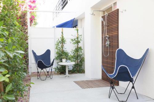 two chairs and a table on a patio at Holiday House Palm Springs in Palm Springs
