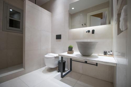 a white bathroom with a sink and a toilet at Thomais Studios in Naxos Chora