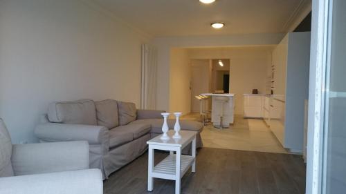 a living room with a couch and a table at lounge appartement zeedijk Oostende in Ostend
