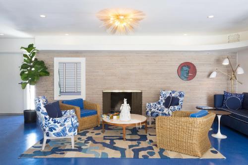 a living room with blue chairs and a fireplace at Holiday House Palm Springs in Palm Springs