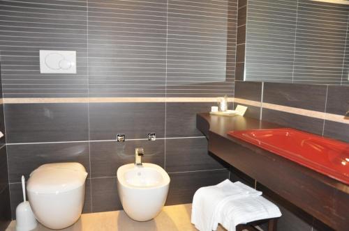 a bathroom with a toilet and a bidet and a sink at Grand Hotel Olimpo in Alberobello