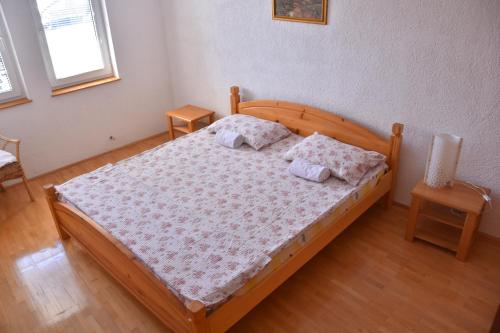 a bedroom with a wooden bed with two pillows at Apartment and Studio Damjan in Ohrid