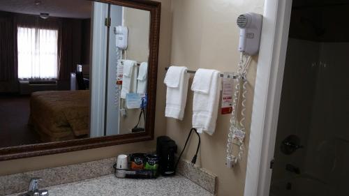 a bathroom with a mirror and a phone on the wall at Super 8 by Wyndham Covington in Covington