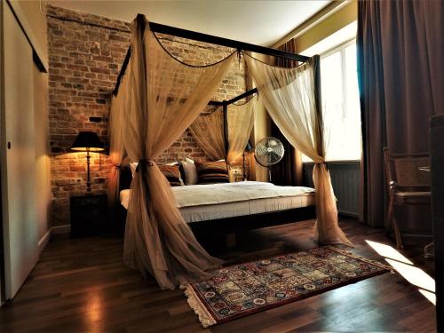um quarto com uma cama de dossel com cortinas e um tapete em SleepWell Apartments Nowy Świat em Varsóvia