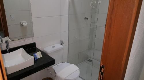 a bathroom with a shower and a toilet and a sink at Pousada Maria Bonita in Arraial d'Ajuda