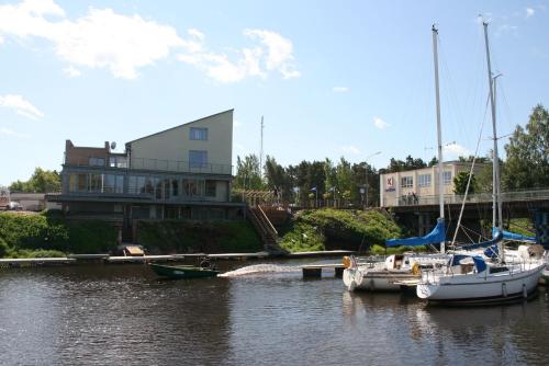 two boats docked in the water in front of a building at Hotel Mare & Restaurant in Roja