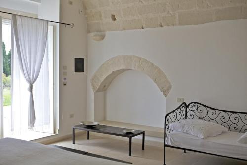 a bedroom with a bed and a table and a window at Masseria Montelauro in Otranto