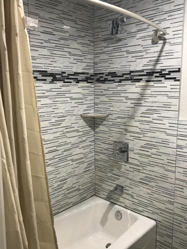 un baño con bañera y lavabo en Executive Suites Inn, en Westminster