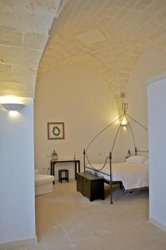 a bedroom with a bed and a table in a room at Masseria Montelauro in Otranto