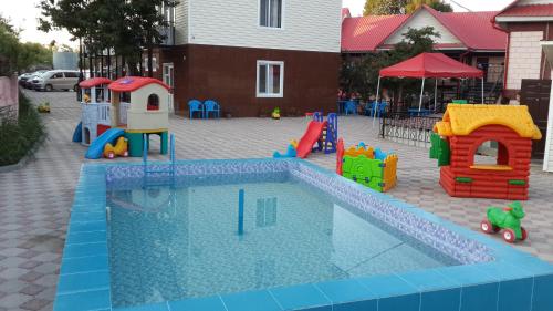 a playground with a small swimming pool with play equipment at Mini-pansionat Maksat in Cholpon-Ata