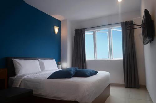 a bedroom with a bed with a large window at Brezza Hotel Sitiawan in Sitiawan