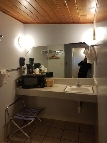 a bathroom with a sink and a mirror at Budget Host Melody Lane in Raton