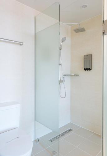a shower with a glass door in a bathroom at Boutique Hotel XYM Pyeongtaek in Pyeongtaek