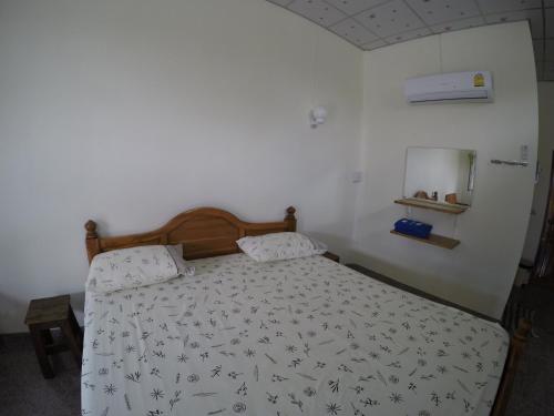 a bedroom with a bed with a black and white comforter at PuengLuang Hotel in Damnoen Saduak
