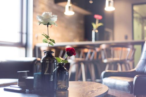 two vases with roses on a table in a restaurant at Boutique Hotel XYM Pyeongtaek in Pyeongtaek