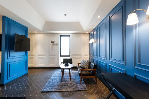 a room with blue walls and a table and a tv at Boutique Hotel XYM Pyeongtaek in Pyeongtaek