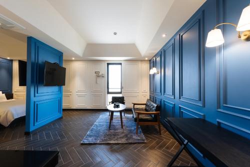 a hotel room with blue walls and a bed at Boutique Hotel XYM Pyeongtaek in Pyeongtaek