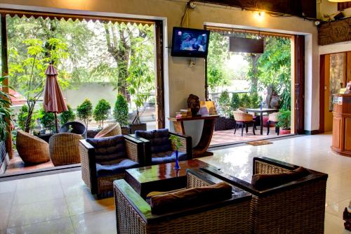 een woonkamer met banken en stoelen en een televisie bij RS II Guesthouse in Phnom Penh