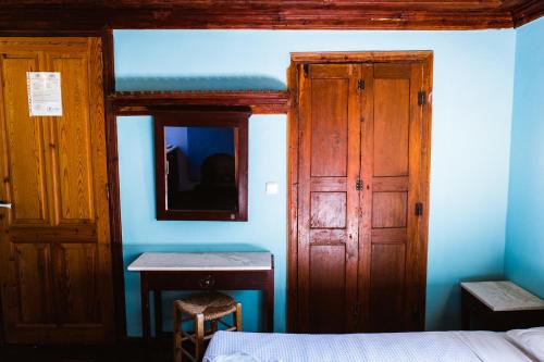 a bedroom with a bed and a desk and a mirror at Karnayo in Meyisti