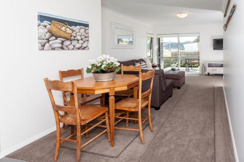 a dining room and living room with a table and chairs at Tides Reach Whitianga in Whitianga