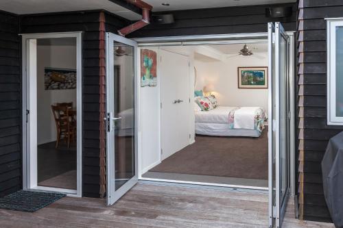a room with a sliding glass door leading to a bedroom at Tides Reach Whitianga in Whitianga