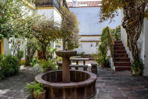 a fountain in a courtyard with a bench and stairs at Casa Ramirez - Guest House in Sucre