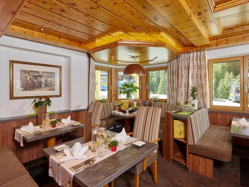 a restaurant with wooden ceilings and tables and chairs at Hotel Gundolf in Sankt Leonhard im Pitztal