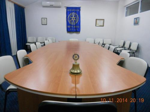 a conference room with a large wooden table and chairs at Family Hotel Helios in Sevlievo