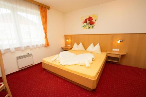 a hotel room with a bed with white sheets at Sunside in Flachau