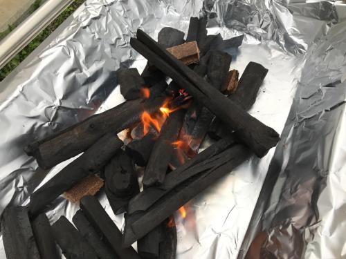 a bonfire with sticks on top of tin foil at Okinawa Pension Minami in Nanjo