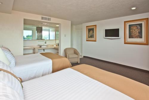 a hotel room with two beds and a bathroom at Holiday Inn Cuernavaca, an IHG Hotel in Cuernavaca