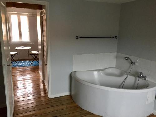 a white bath tub in a room with a floor at Lumières B&B in Lille