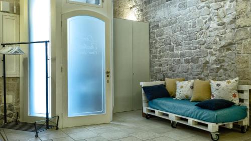 トラーニにあるDonna Isabellaの青いソファとレンガの壁が備わるリビングルーム