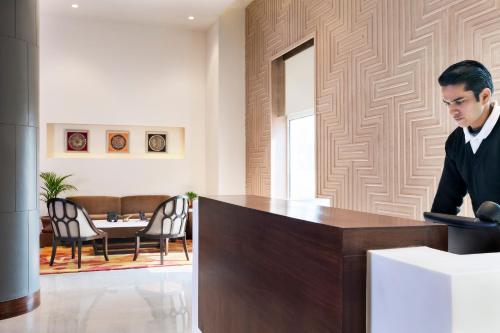 een man aan een bureau in een kamer bij Oaks Bodhgaya in Bodh Gaya