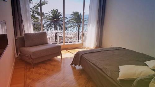 ニースにあるFlorida - Promenade des Anglaisのベッドルーム1室(ベッド1台、椅子、窓付)