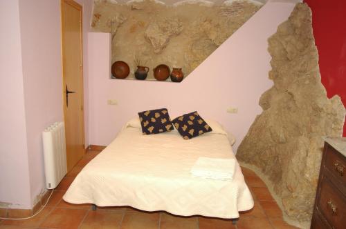 een slaapkamer met een bed met 2 kussens erop bij Casa Cami Real in Villafranca del Cid