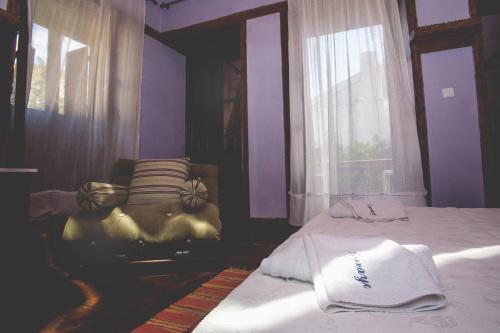 a purple bedroom with two beds and a chair at Karnayo in Meyisti