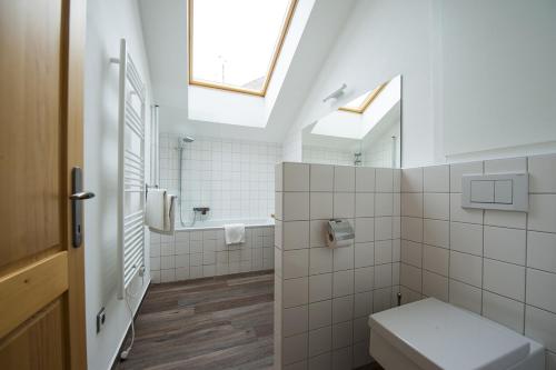 La salle de bains blanche est pourvue de toilettes et d'une fenêtre. dans l'établissement Vinařství Šílová, à Mikulov