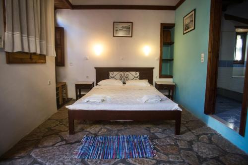 a bedroom with a bed and a rug on the floor at Karnayo in Meyisti