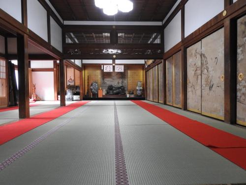 an empty room with a red and white carpet and walls at Sekishoin in Koyasan