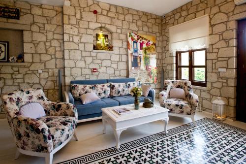 a living room with a blue couch and two chairs at Lodos Hotel in Alacati