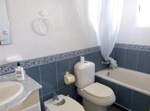 a bathroom with a toilet and a sink and a tub at Apartamentos Arenales Del Sol III in Arenales del Sol