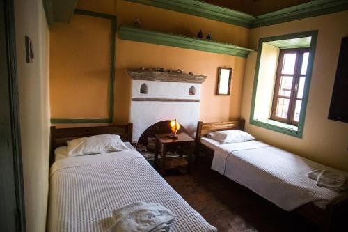 a room with two beds and a fireplace in it at Karnayo in Meyisti