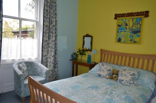 a bedroom with a bed with a teddy bear on it at The Spindle Guest Rooms in St. Andrews