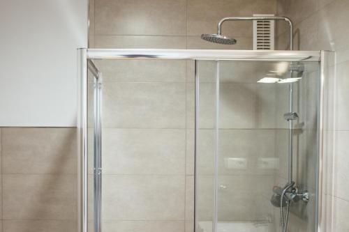 y baño con ducha y puerta de cristal. en Botànic Apartaments, en Valencia