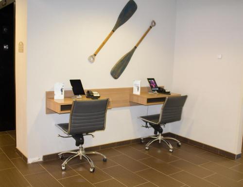 an office with two desks and two paddles on the wall at Microtel Inn & Suites by Wyndham - Penn Yan in Penn Yan